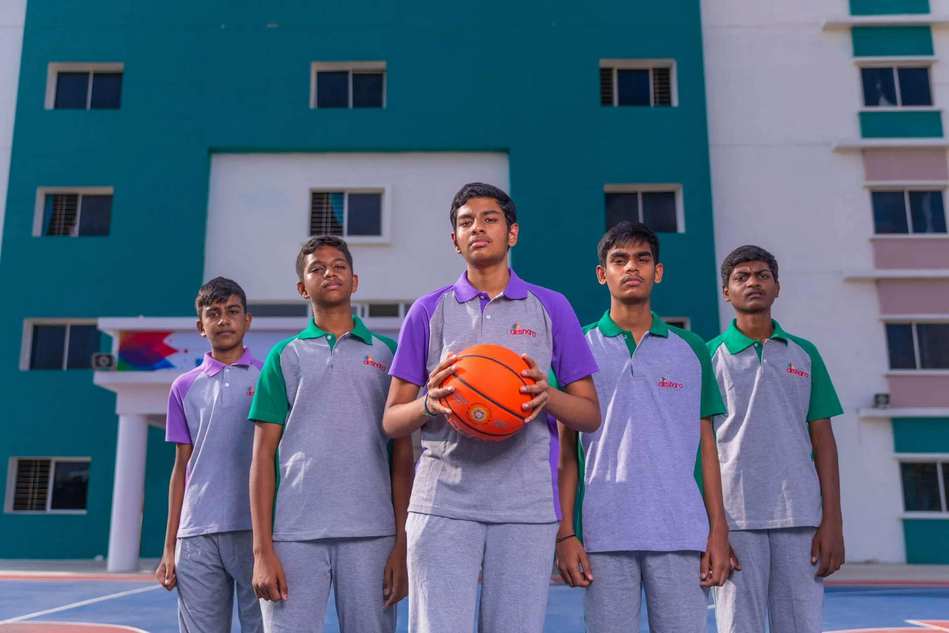 Akshara basketball team posing with a ball