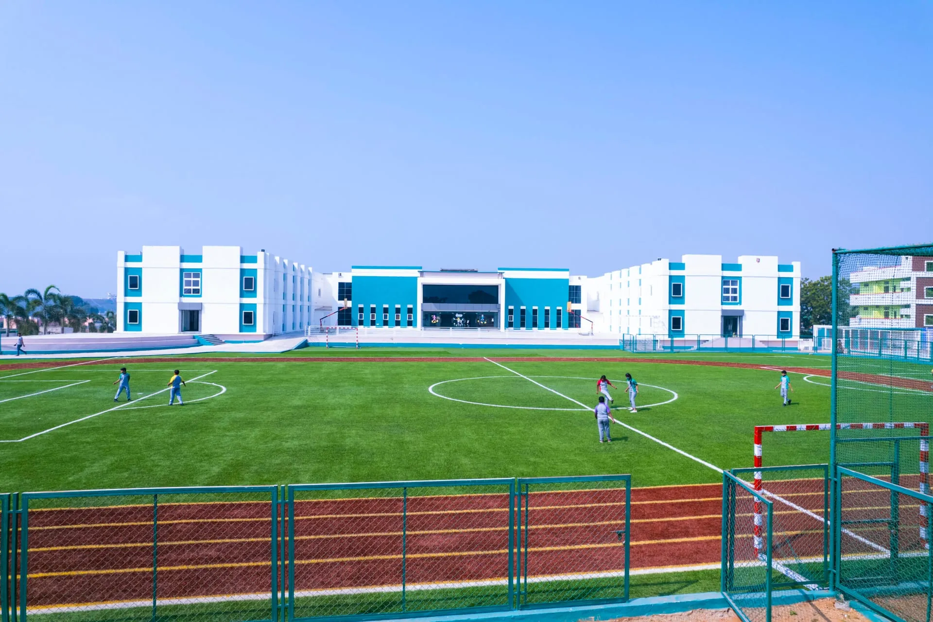 Aerial view of an Akshara International School campus with its football field and school buildings