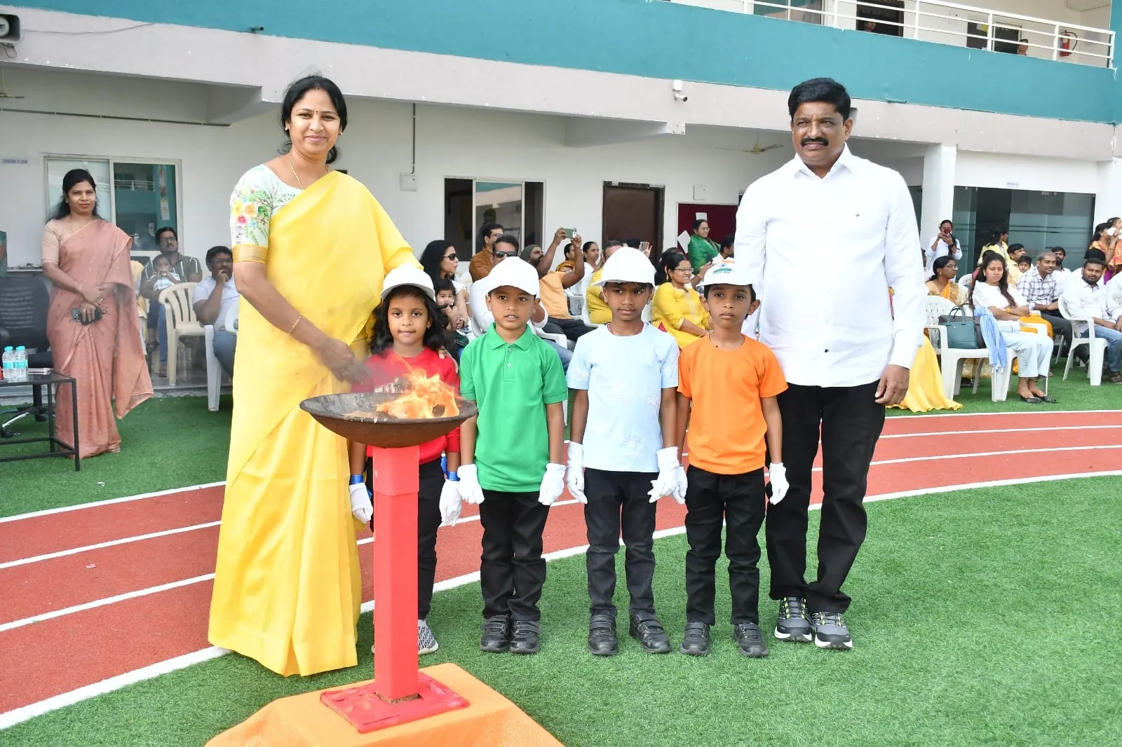 Pre-primary children lighting the torch at the Akshara Mini Olympics on Republic Day