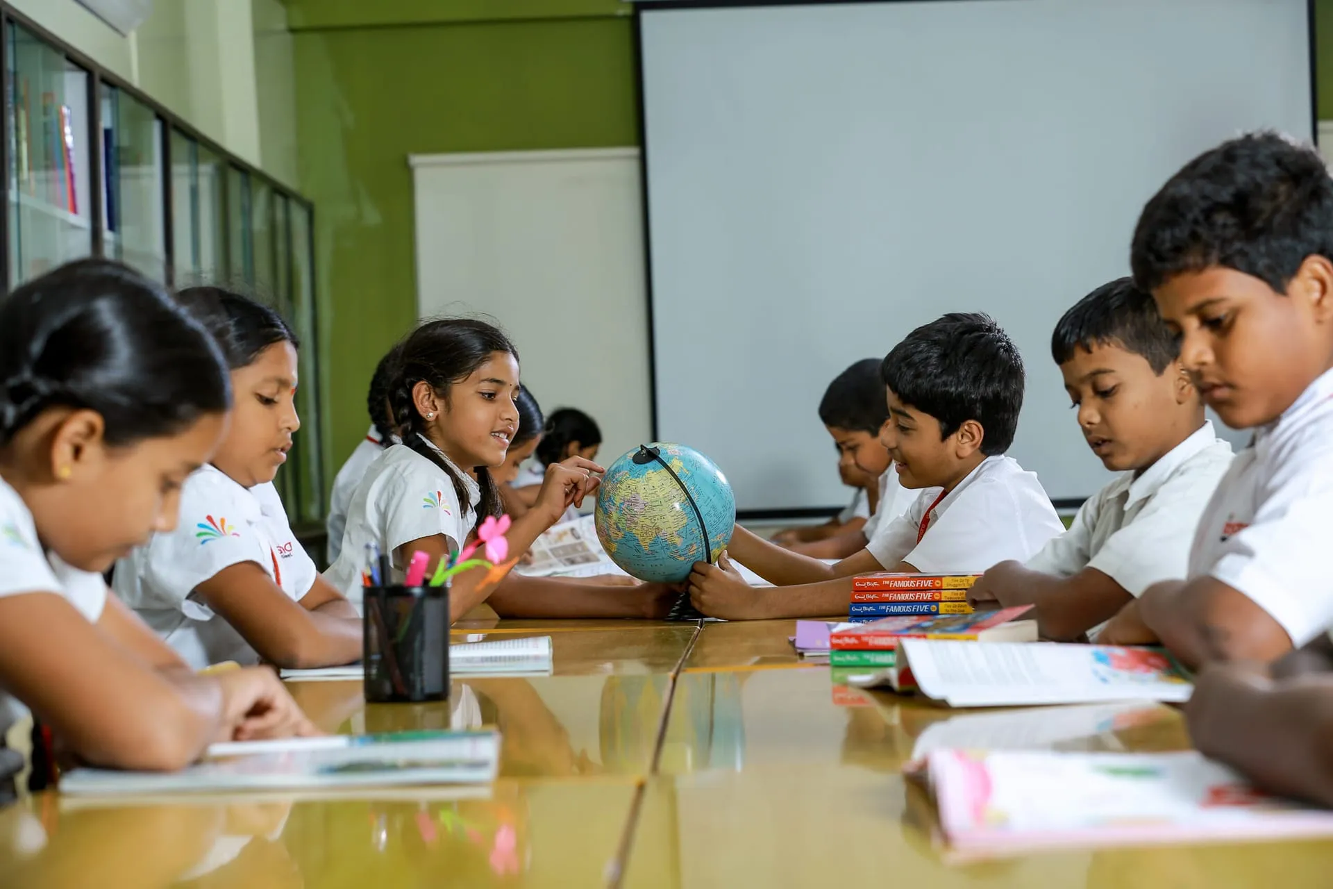 Primary students working with a globe in class