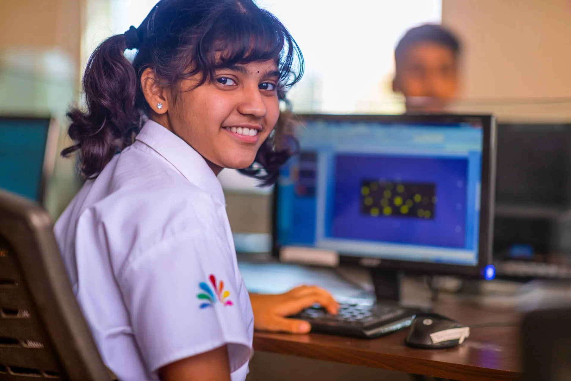 Smiling student working at a computer in the lab