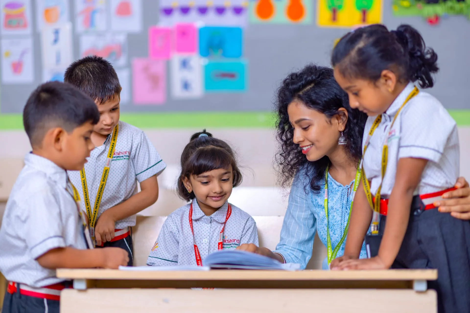 Teacher reading with young Akshara pupils in a bright classroom